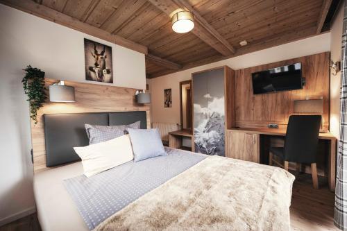 a bedroom with a bed and a desk with a computer at Golf & Ski Chalet in Mittersill