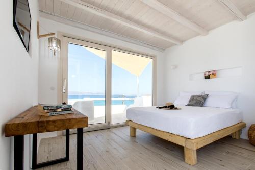 1 dormitorio con cama y ventana grande en Apartments enosis, Triton en Agia Anna Naxos