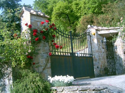 a green gate with red flowers on it at B&B Casa Rosella - Country house in Bellegra