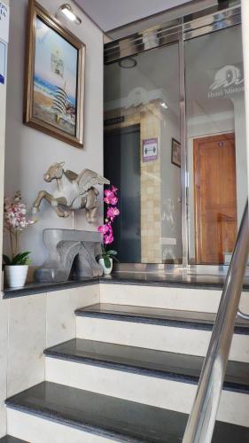 a group of stairs with a statue and flowers at Hotel Miraya Beach in Torre del Mar