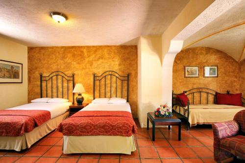 a hotel room with two beds and a couch at Villa Colonial in Antigua Guatemala