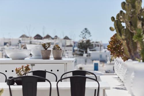 a table and chairs on a balcony with cactus at Elaia Luxury Suites Mykonos in Mýkonos City