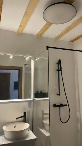 a white bathroom with a sink and a shower at Casa Thymus in Soveja