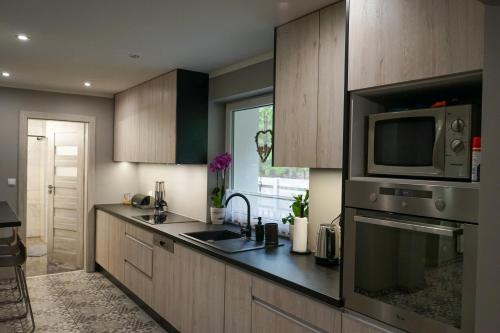 a kitchen with a sink and a microwave at Agroturystyka PLENER in Miedzichowo