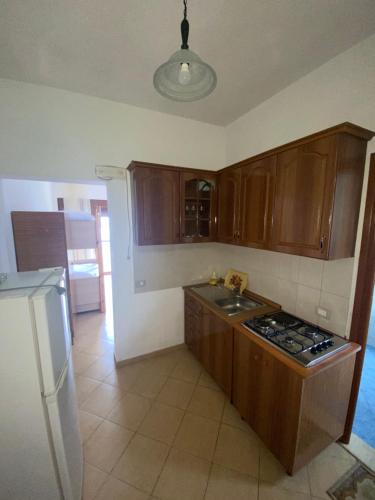 a kitchen with wooden cabinets and a stove top oven at Pararse Apartments in Vlorë