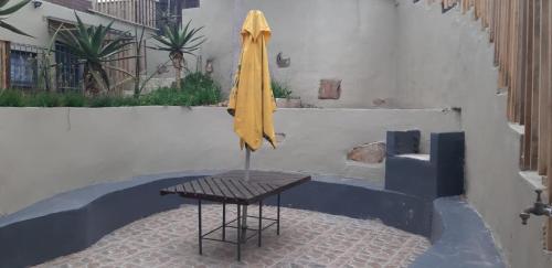 a yellow umbrella sitting on a table in a courtyard at Ocean Rush in Zinkwazi Beach