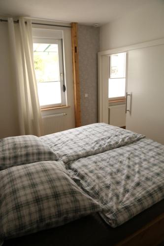 a bedroom with a bed and two windows at Ferienwohnung Evi in Walkenried