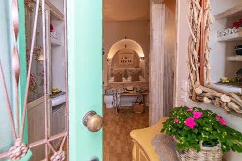 a hallway with a mirror and a table with a plant at Madalena's Family Rooms in Tinos