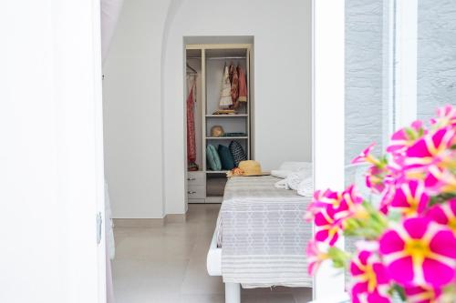 Habitación blanca con cama y flores rosas en Palestro 5, en Leverano