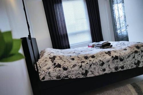 Bett in einem Zimmer mit Fenster und Spiegel in der Unterkunft Amazing Apartment Toppilansaari in Oulu