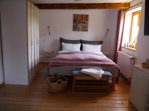 a bedroom with a bed with a red blanket and a window at "Heckenrose" in Ilsenburg