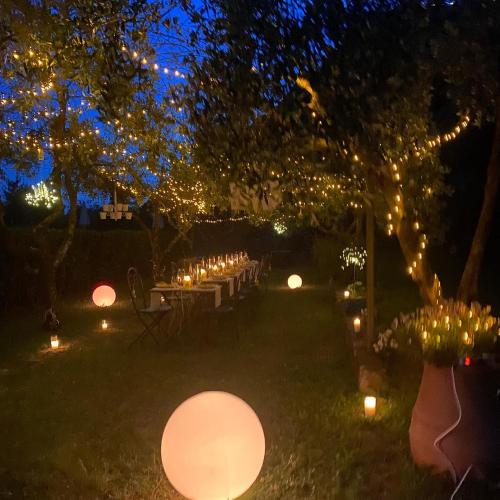 a group of tables with candles and lights at night at Sotto il cielo di Toscana appartamenti in tenuta only adults no pet in Camaiore