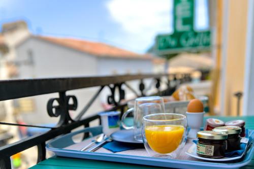 巴拉呂克萊班的住宿－Hôtel du Golfe Sete-Balaruc，桌上装有一杯橙汁的托盘