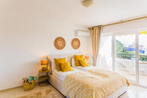 Un dormitorio con una cama con almohadas amarillas y una ventana en Suite Bora Bora, en Marbella