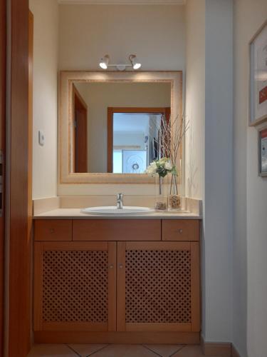 La salle de bains est pourvue d'un lavabo et d'un miroir. dans l'établissement Cantinho do Burgau, à Burgau