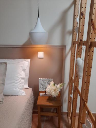 Un dormitorio con una cama y una mesa con flores. en Cantinho do Burgau, en Burgau