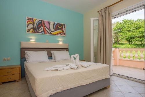 1 dormitorio con 2 camas y ventana en Villas Porto Odysseas Afionas Corfu, en Afionas