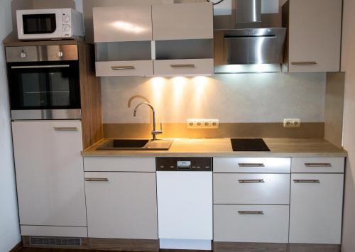 a kitchen with white cabinets and a sink at Abendsonne in Stralsund