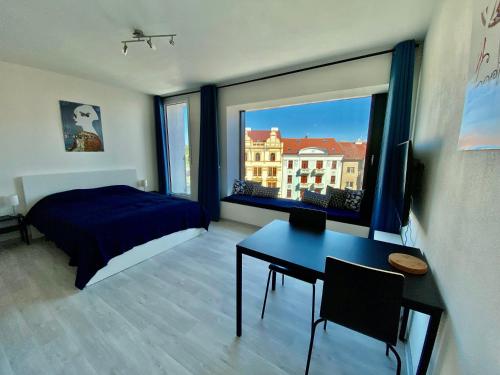 a bedroom with a bed and a desk and a window at COZY STUDIO WITH GARAGE IN THE CITY CENTER in Plzeň