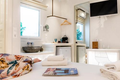 a living room with a sink and a table at Anastasia's Visage Stylish Accommodation Rooms City Centre Mykonos in M&yacute;konos City