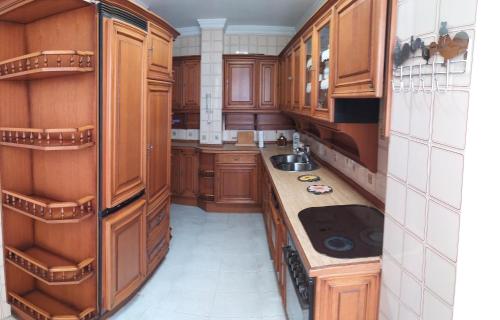 a large kitchen with wooden cabinets and a sink at Casa Érika in Puerto del Rosario