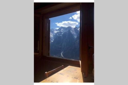 a window in a room with a view of a mountain at Alpia 26 - Zwei Zimmerwohnung in traditionellem Walliser Haus in Gasenried