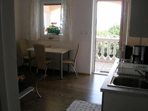 eine Küche mit einem Tisch und Stühlen sowie einem Fenster in der Unterkunft Apartment in Mošcenicka Draga with sea view, balcony, air conditioning, Wi-Fi (4772-1) in Mošćenička Draga