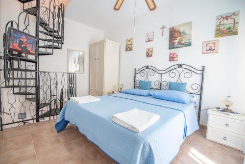 a bedroom with a blue bed with blue pillows at Appartamento Peralta 20 in Centro in San Vito lo Capo
