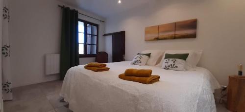 a bedroom with a white bed with two towels on it at Forcal in Forcalquier