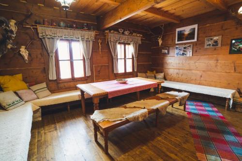 a living room with a table and benches in a cabin at Chata pod Rozsutcom in Terchová
