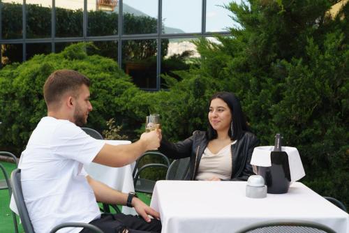 a man and a woman sitting at a table with a glass at Hotel Cristallo di La Rosetta Srl in Assisi