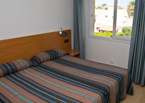 Aparthotel Villas La Manga tesisinde bir odada yatak veya yataklar