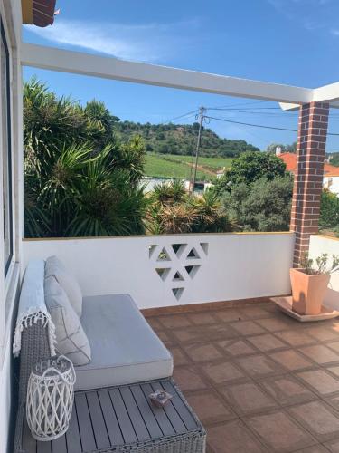 a balcony with a couch and a view of the ocean at Quinta Ribeira do Labrador - Lisbon West Wine Route in Alenquer