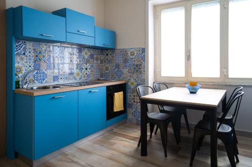 a kitchen with blue cabinets and a table with chairs at B&B Sogno - Camere con vista a Vietri Sul Mare in Vietri