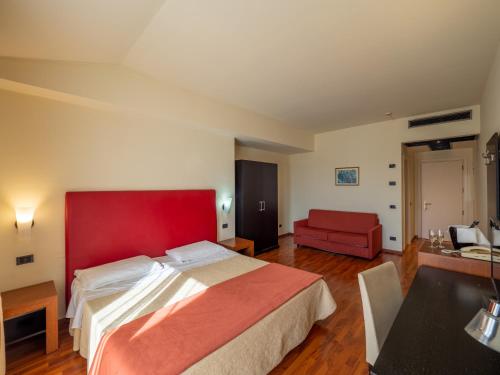 a bedroom with a red bed and a red chair at Hotel Cristallo di La Rosetta Srl in Assisi