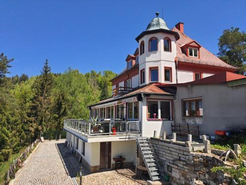 a large house with a tower on top of a hill at Hotel Panorama in Jáchymov