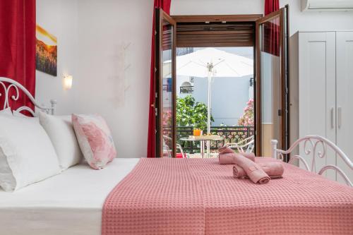 a bedroom with a bed with a pink blanket at NAXOS DIAMOND Studios Apartments in Naxos Chora