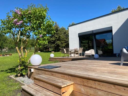 a backyard with a wooden deck and a house at VILLA DANUTA- WISELKA, direct at National Park, big garden, 4 bedrooms, private SAUNA in Wisełka