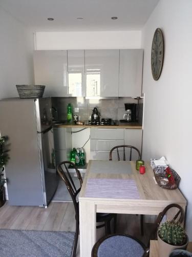 a kitchen with a table with chairs and a refrigerator at MIESZKANIE 30M in Giżycko