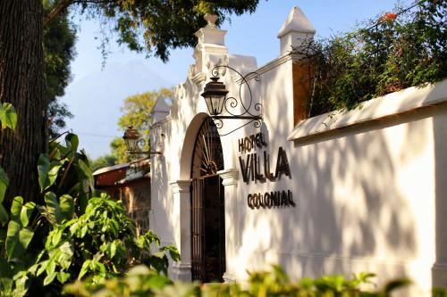 an entrance to a white building with a sign on it at Villa Colonial in Antigua Guatemala