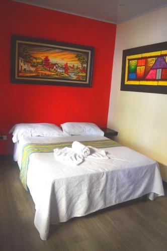 a bedroom with two beds and a red wall at Millenium Manuel Antonio Park and beach in Manuel Antonio