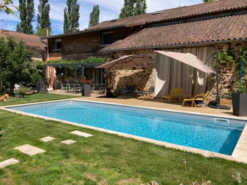 a swimming pool in a yard next to a house at Les Chambres Lauryvan in Saint-Junien