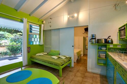 Habitación con paredes verdes y azules y sofá. en SOLEIL COUCHANT - Gîtes en Deshaies
