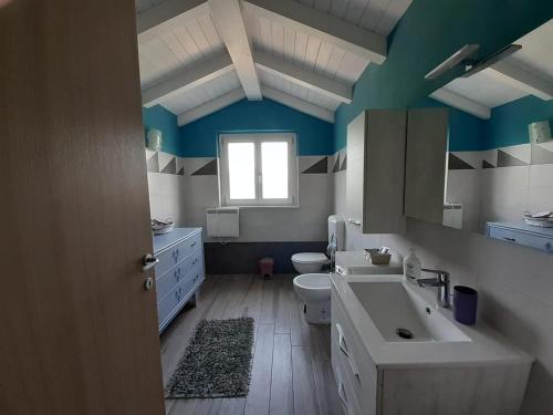 a bathroom with a sink and a toilet and a window at Casa Vacanze I Boidi in Nizza Monferrato