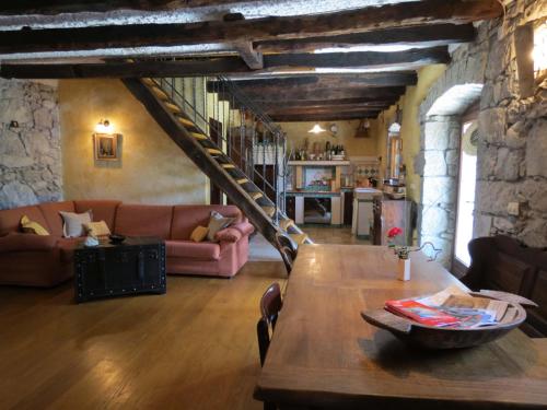 a living room with a table and a staircase at Poolhouse Roc (3458) in Roč