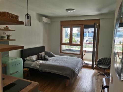 een kleine slaapkamer met een bed en een raam bij Wellport30 in Belgrado