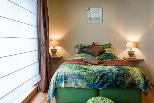 ein Schlafzimmer mit einem Bett, zwei Lampen und einem Fenster in der Unterkunft Adamas B&B in Dendermonde