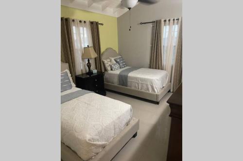 a bedroom with two beds and a lamp on a table at Villa Kalaya in Mammee Bay