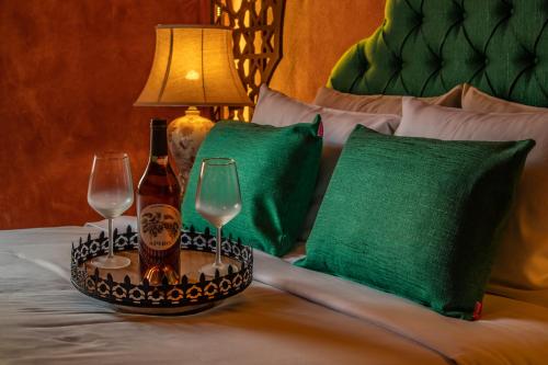 a bed with two wine glasses and a lamp on it at DECAN Concept Boutique Estate in Rhodes Town