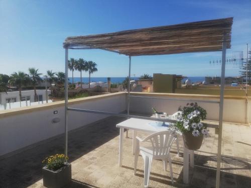 a patio with a table and chairs on a roof at Villa Sunshine in Triscina